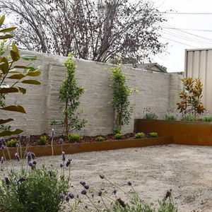 Overview of the Patterson Residence outdoor space with gravel pathways, raised garden beds, and a mix of screening and accent plants providing privacy and a sensory experience.