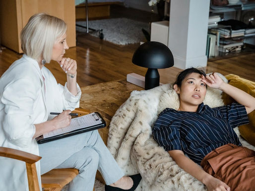 Anxiety treatment Miami session with a therapist taking notes while a client talks on a couch