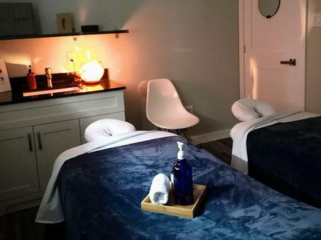 Private couples massage room with two massage tables, dim lighting, and a calm spa atmosphere at Refresh Massage Mississauga.