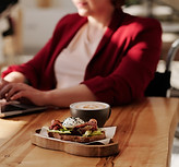 woman-in-red-blazer-sitting-by-the-table