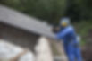 a asbestos removal worker looking closely at a roof