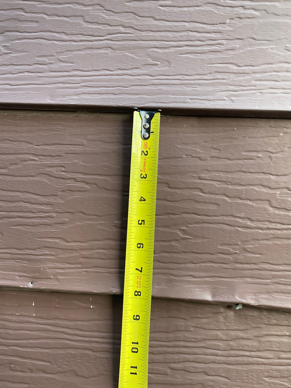 Old 8 inch aluminum siding panels showing both hail hits and other non-hail damage on Warwick Ave in Chicago, Illinois replaced by TomKat Restoration