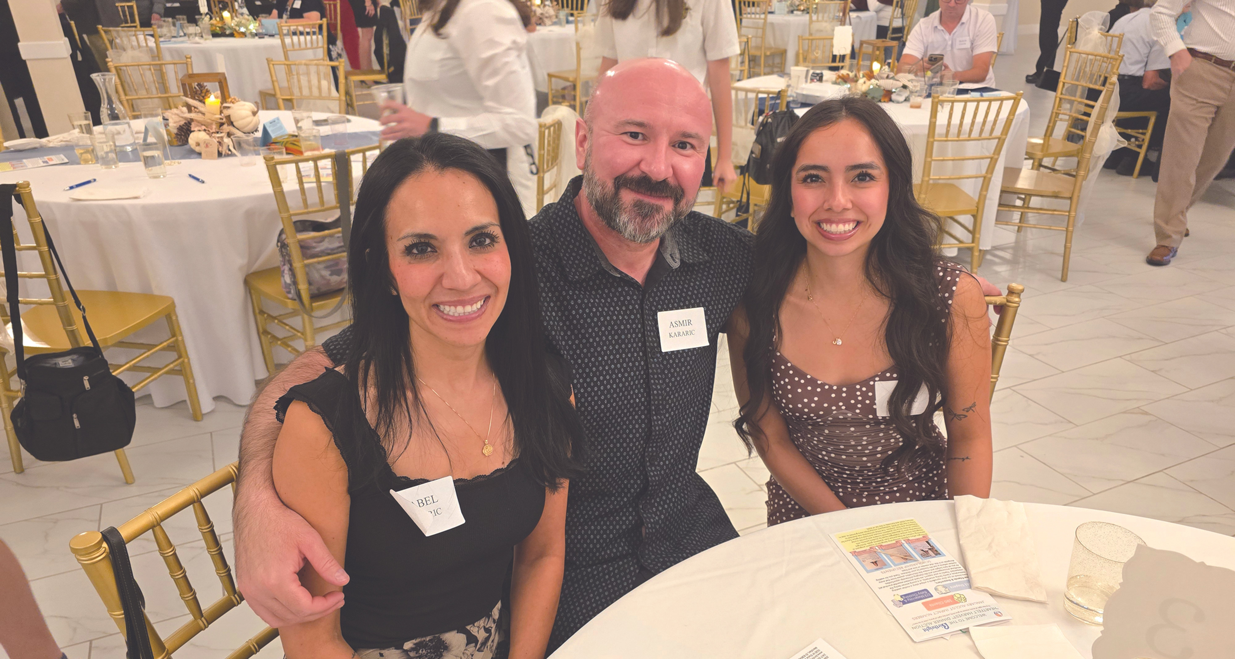 family of three poses at a dinner auction