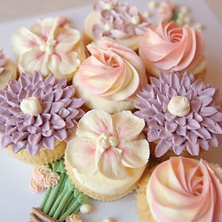 Edible flower cupcake bouquet with nine vanilla cupcakes decorated in buttercream blooms, popular for Mother’s Day classes and baking experiences