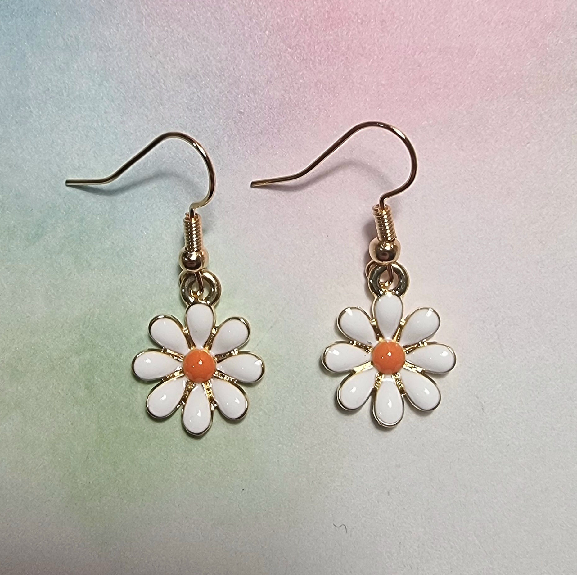 Cute white enamel daisy flower drop earrings with gold-toned hooks.