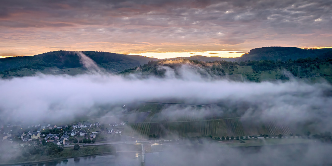 Nebelzungen greifen über die Hügel des Moseltals, ein Dorf wird zur Insel – Eulenwerk, Mont Royal bei Traben-Trarbach