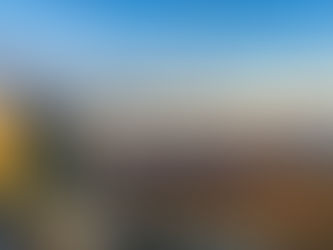 Weitblick vom Gipfel des Ölbergs über das herbstliche Siebengebirge: goldene Felsen im Vordergrund, dahinter sanft beleuchtete Hügelketten, Nebelschwaden in den Tälern und ein klarer Himmel im frühen Morgenlicht.