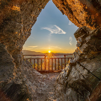 Sonne mit sternförmigen Strahlen im Felsrahmen des Teufelslochs bei Altenahr.