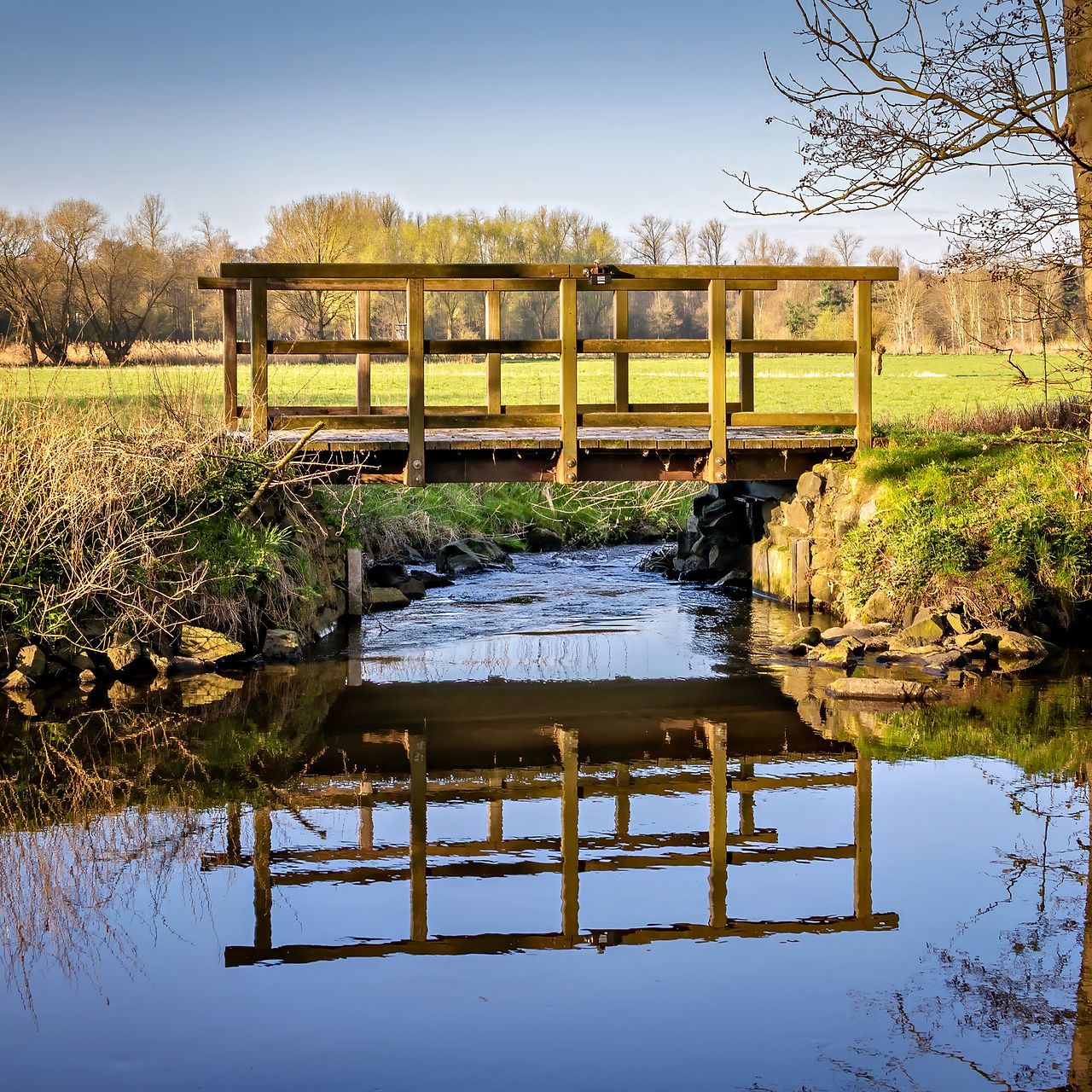 Eine Brücke über einen schmalen Kanal in der Moorlandschaft
