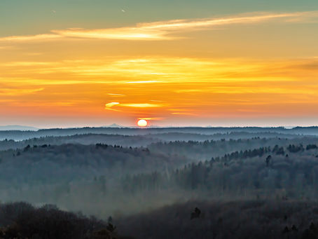 Sonnenaufgang über den nebelverhangenen Bergen der Eifel