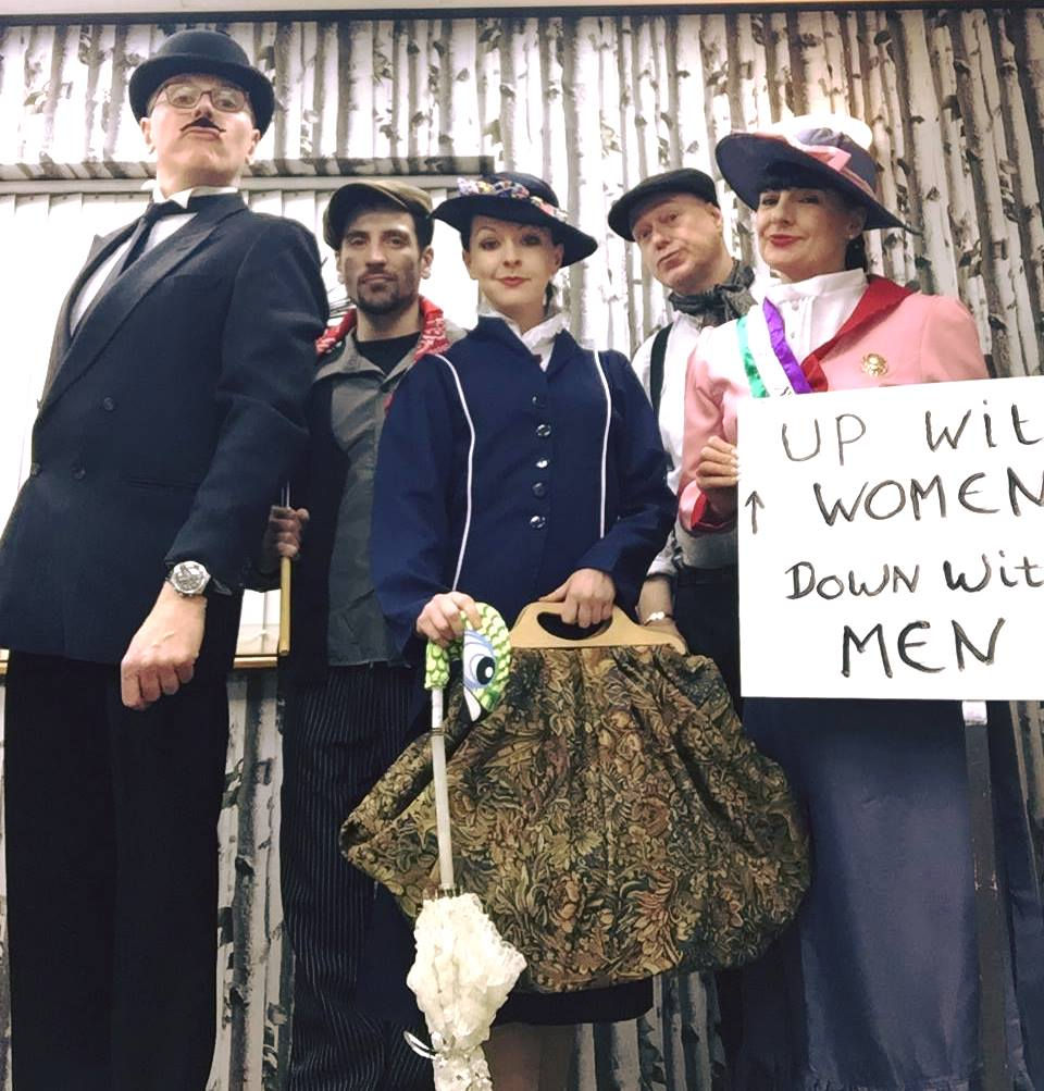 A group of people dressed in costume for murder mystery party all posing for the camera.