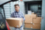 Serious handsome young man in casual clothing finding place in car for cardboard box while