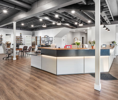 Modern office reception desk with industrial ceiling and wood floors