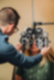 Optometrist performing eye exam with phoropter