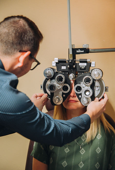 Optometrist performing eye exam with phoropter