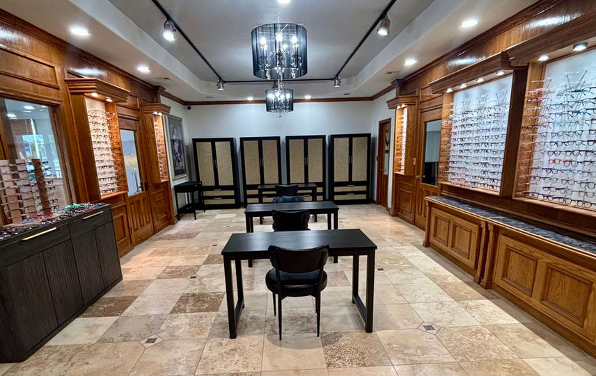 Optical store showroom with wooden display cases and desks