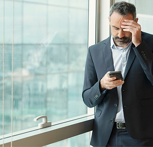 Stressed man with eye strain checking phone in Daly City