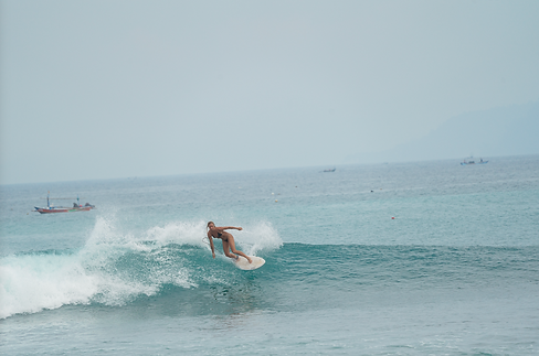 Stephanie Baird founder and host of Sundazed Retreats, surfing a beautiful wave in Sumatra, embodying adventure and skill during tropical surf experiences.