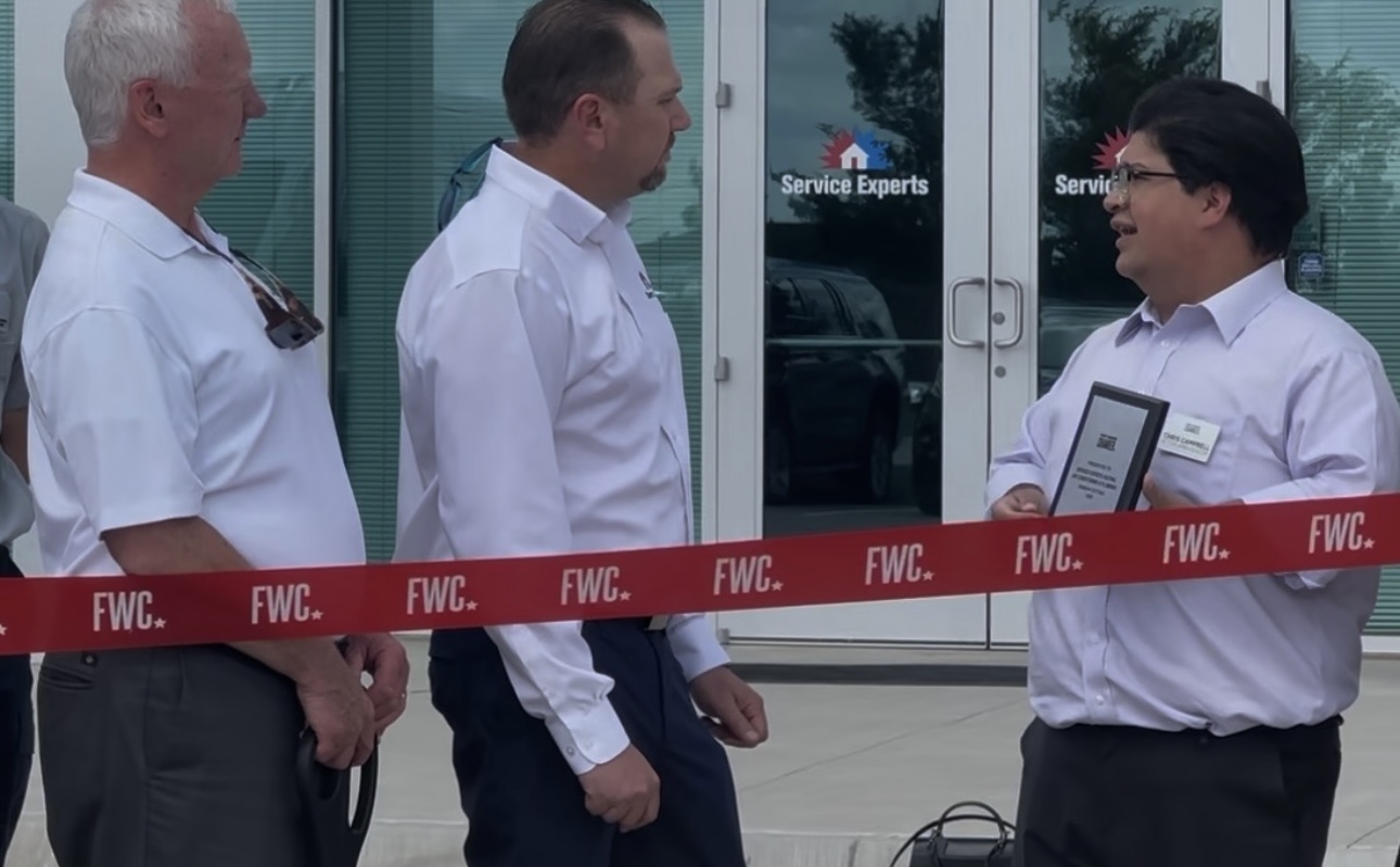 Donny Chris Campbell holding a plaque at an FWC ribbon cutting.