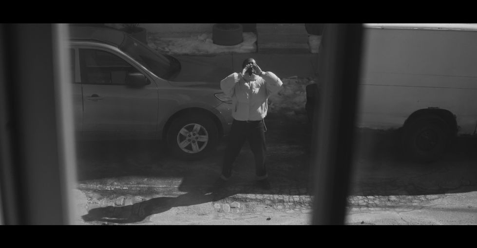 Distressed person with hands on head, framed by bars