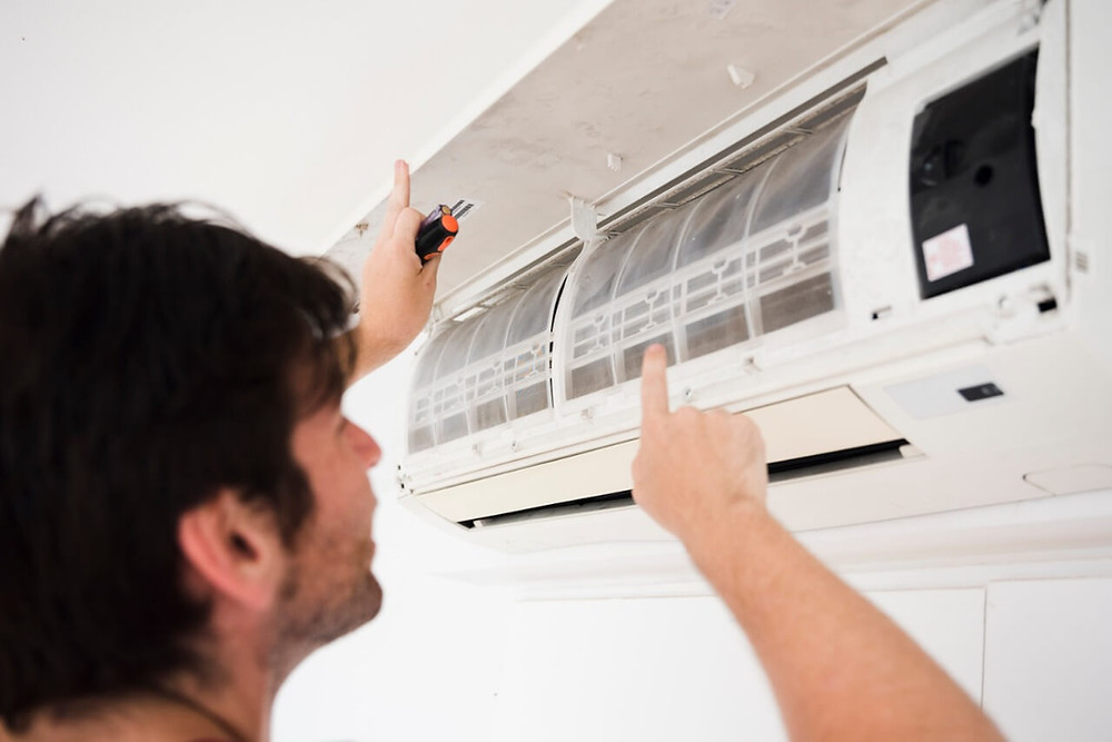 técnico realizando manutenção no ar condicionado