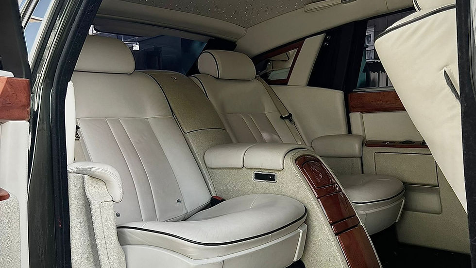 Rolls-Royce Phantom luxury rear cabin featuring cream leather seating, wood trim and starlight headliner, offering first-class chauffeur-driven comfort for VIP travel and executive transport in London.