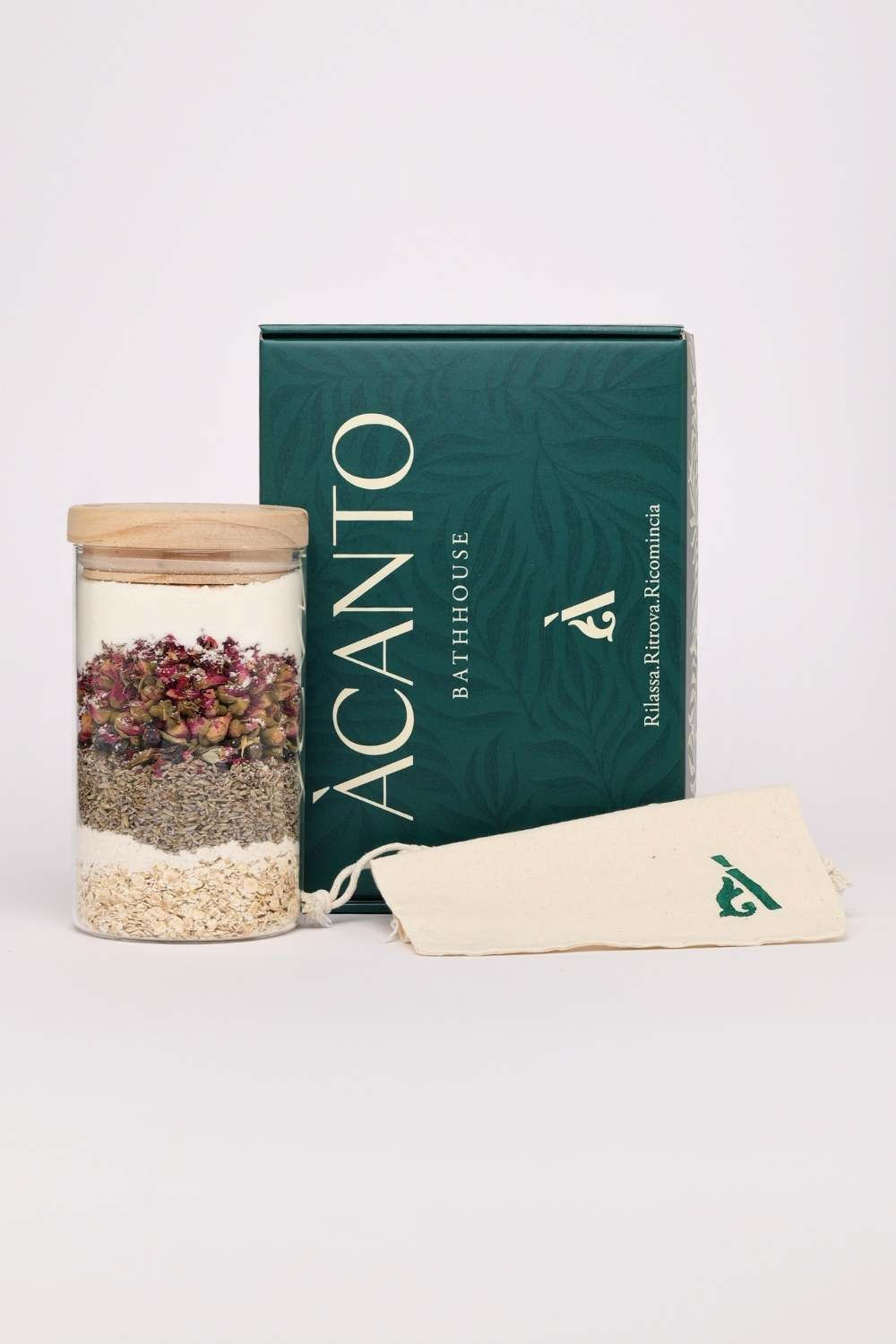 Esempio Kit benessere Àcanto Bathhouse con miscela di erbe officinali, rose, cocco e sacchetto in tessuto su sfondo neutro.