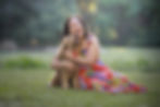 A woman laughing with her spoodle dog