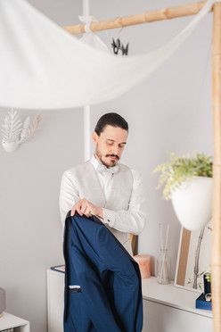 Un uomo elegante si sta vestendo, mettendo la sua giacca con precisione e stile