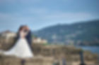 Una coppia di sposi abbracciati per una foto sulle rocce in riva al lago maggiore