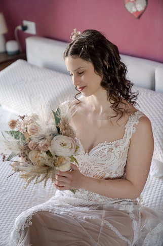 una sposa sorridente osserva felice il bouquet, fotografo matrimonio lago d'orta