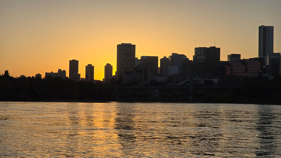 Eye-level view of a jet boat cruising along Edmonton's river valley with downtown skyline in the background