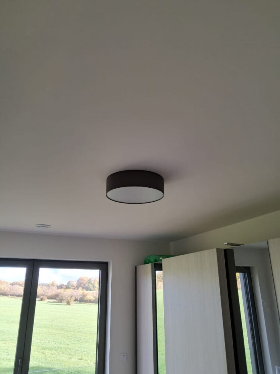 Pose d'une applique au plafond, dans une pièce de la maison.