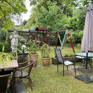 Vue extérieure du restaurant sur l'aire de jeu avec tables et chaises.