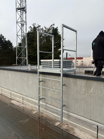 Mise en place d'une échelle de sécurité métallique sur un bâtiment.