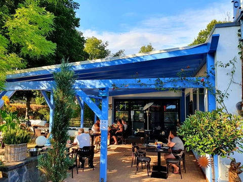 Terrasse extérieure du restaurant sous à un abris de couleur bleu