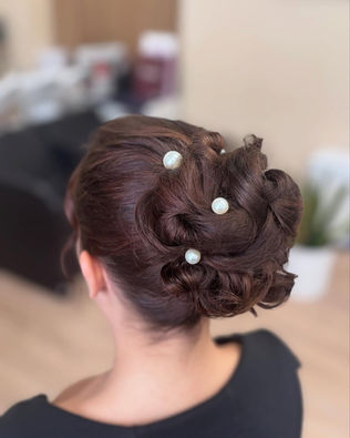 Coiffure de cérémonie avec chignon et des perles blanches à l'intérieur