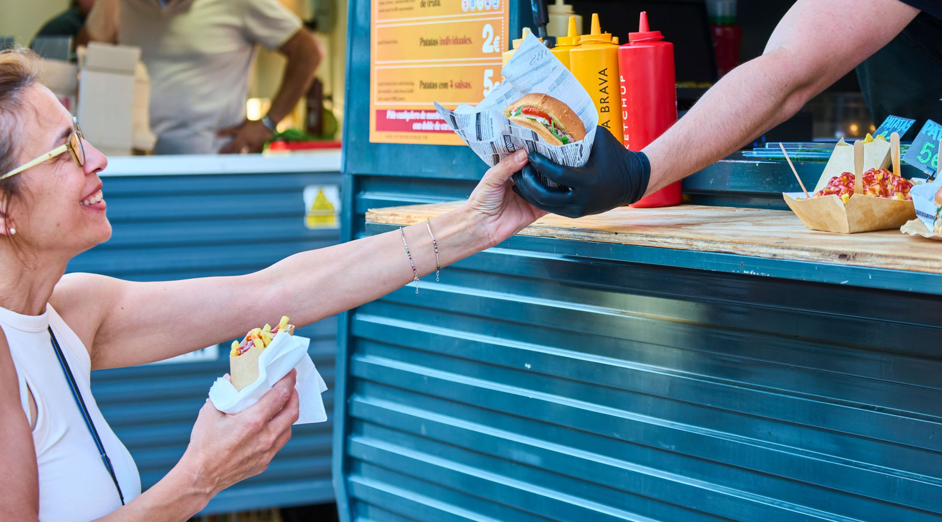 Femme heureuse attrapant un hamburger pendant un festival de food truck de hamburger.