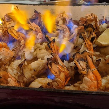 Gros plan sur le plat de scampis grillés et flambés Chez Isabel Bacano.
