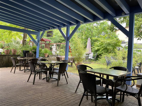 Extérieur du restaurant avec devanture, tables et chaises.