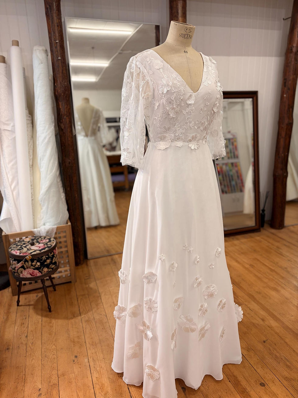 Robe de mariée bohème chic en dentelle florale 3D et mousseline de soie, vue de dos avec transparence élégante.