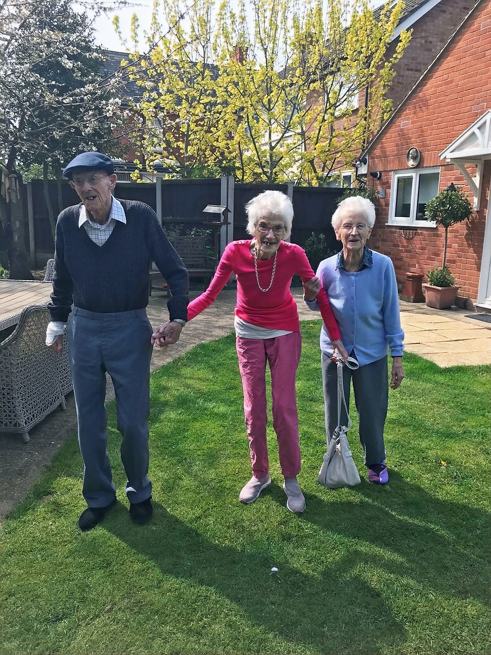 three resdents outside in the garden having fun