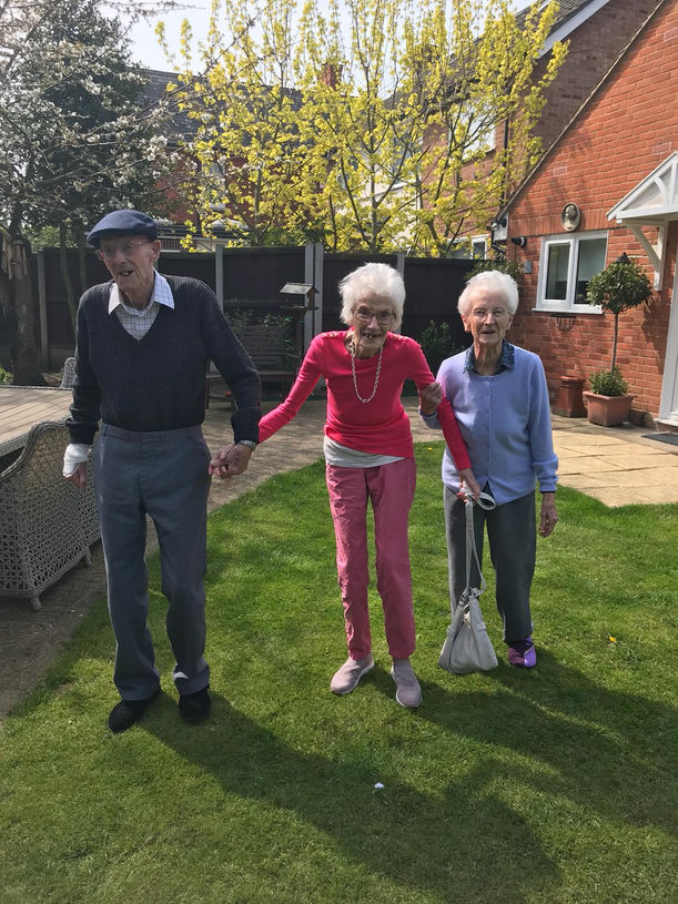 3 care home residents enjoying time in the garden