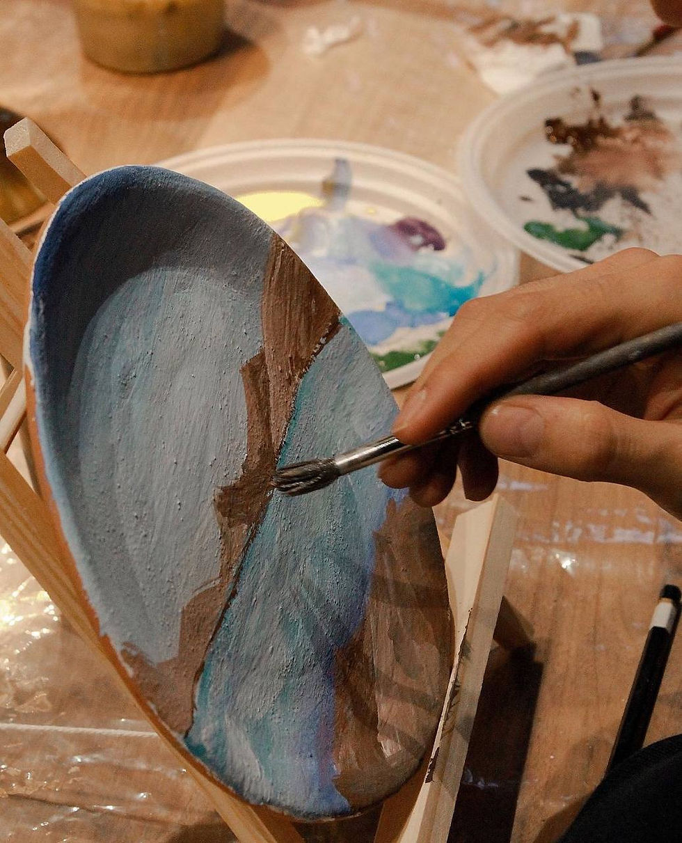Eye-level view of a street artist painting a mural in a vibrant NYC neighborhood