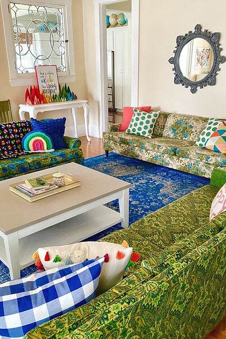 Colorful living room with two couches, pillows and a coffee table.