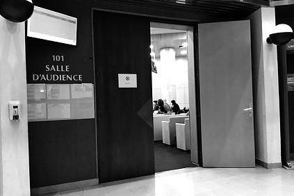 Image en noir et blanc d'une porte d'entrée menant à une salle d'audience