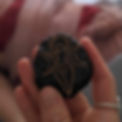 Hand holding a stone with woman and moon figure