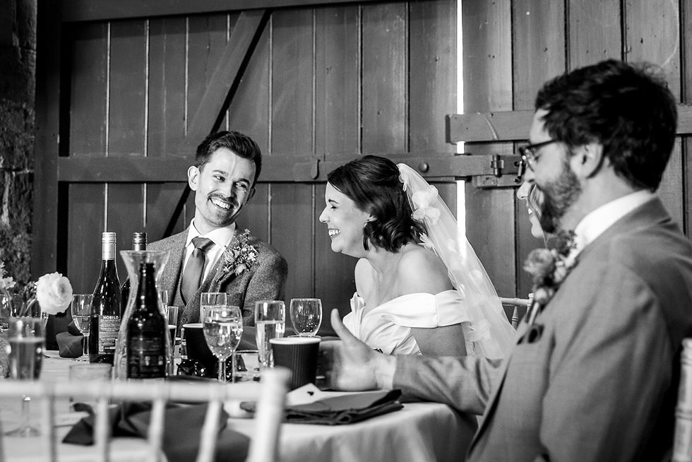reception in full swing, laughing and smiling in the cotswold stone barn at Cogges Manor Farm, Witney, Oxfordshire