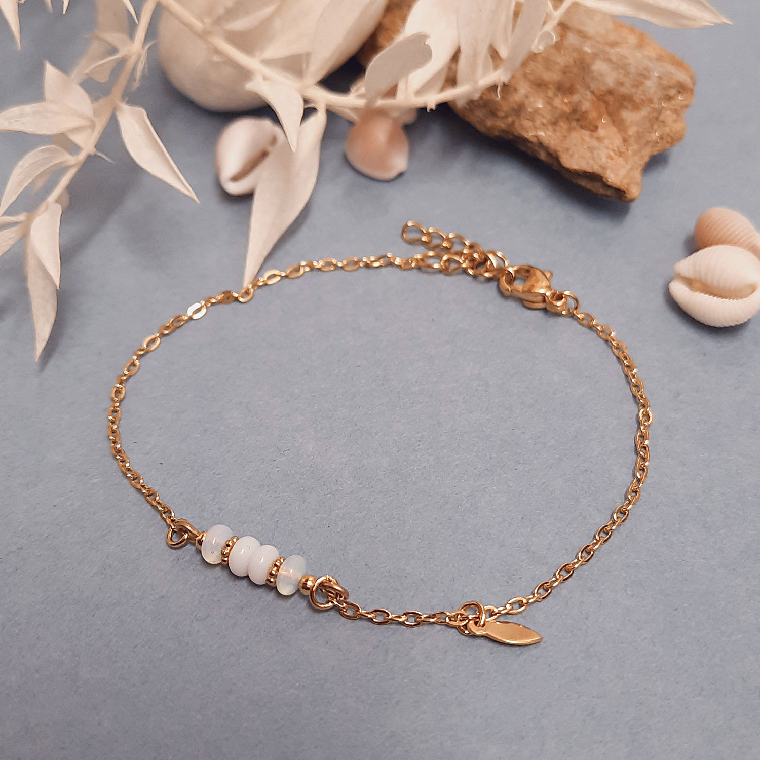 Bracelet blanc et doré avec pierres naturelles et chaînette en acier inoxydable doré.