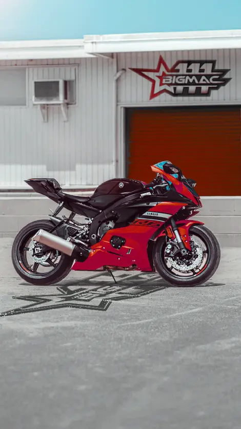 a red and black yamaha r6 motorcycle is parked in a parking lot